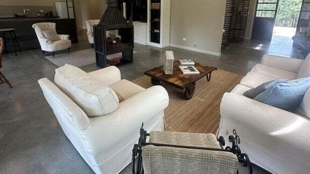 Ein modernes Wohnzimmer mit Kamin, weißen Ledersofas und einem Essbereich.