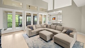 A spacious living room with a large sectional sofa, a coffee table, and a dining area with a table and chairs. - Stunning pool home steps to beach! REDUCED! (Sanibel)