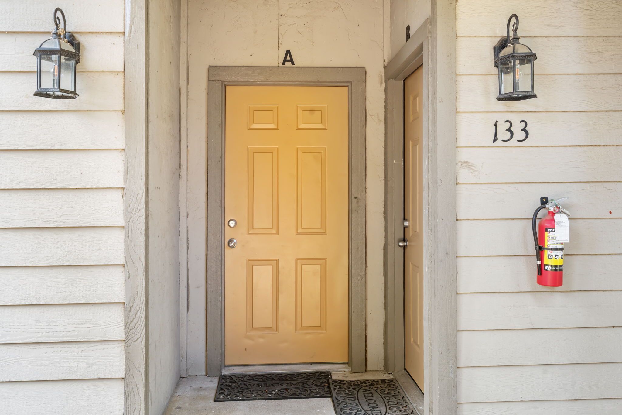 A wooden door with a number 133 on the wall to the right.