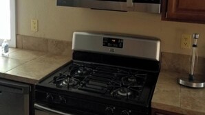 A kitchen with a stainless steel microwave and stove, wooden cabinets, and a countertop. - Short term rentals and corporate housing.  Up to 25% discounts for longer stays (Winnemucca)