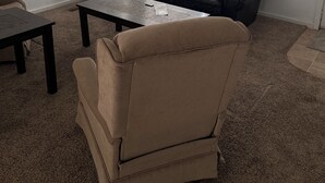 A living room with a dark brown leather sofa, a beige armchair, and a small black coffee table. - Short term rentals and corporate housing.  Up to 25% discounts for longer stays (Winnemucca)