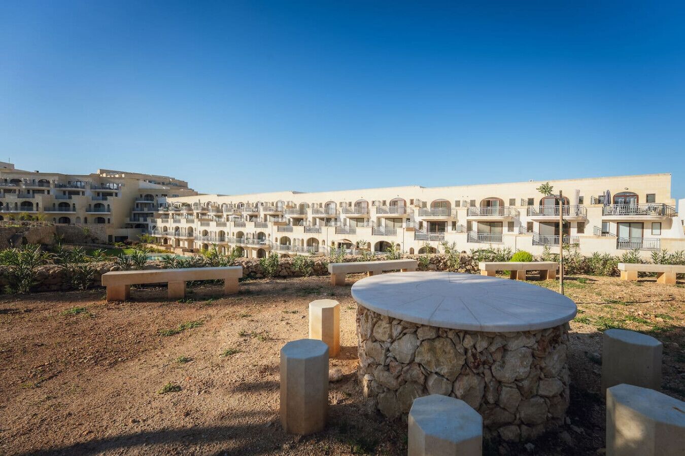 A hotel courtyard with outdoor seating and a pool.