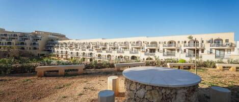 A hotel courtyard with outdoor seating and a pool.