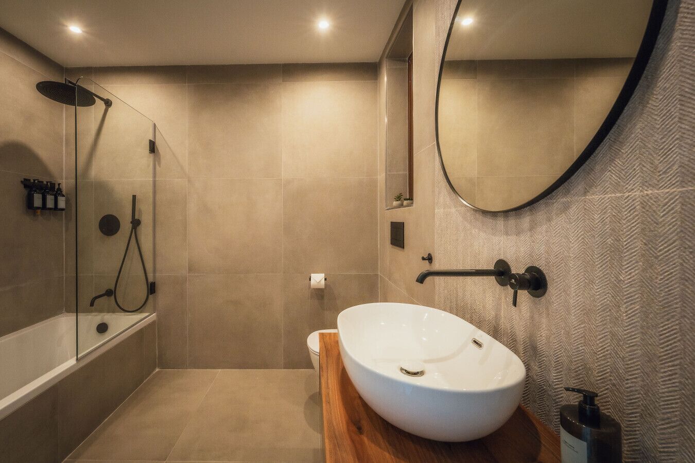 A modern bathroom with a freestanding bathtub, a walk-in shower, and a large mirror.