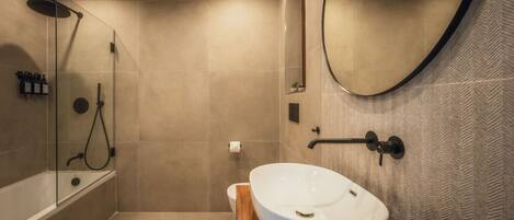 A modern bathroom with a freestanding bathtub, a walk-in shower, and a large mirror.