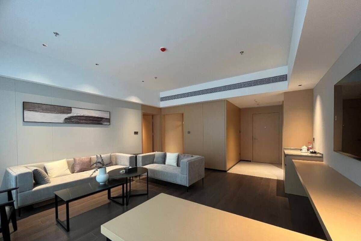 A modern living room with a sectional sofa, a coffee table, and a TV.