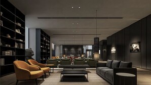 A modern library with a central seating area, bookshelves, and a large bear sculpture. - SHILIA STAY YANCHENG (Yancheng)