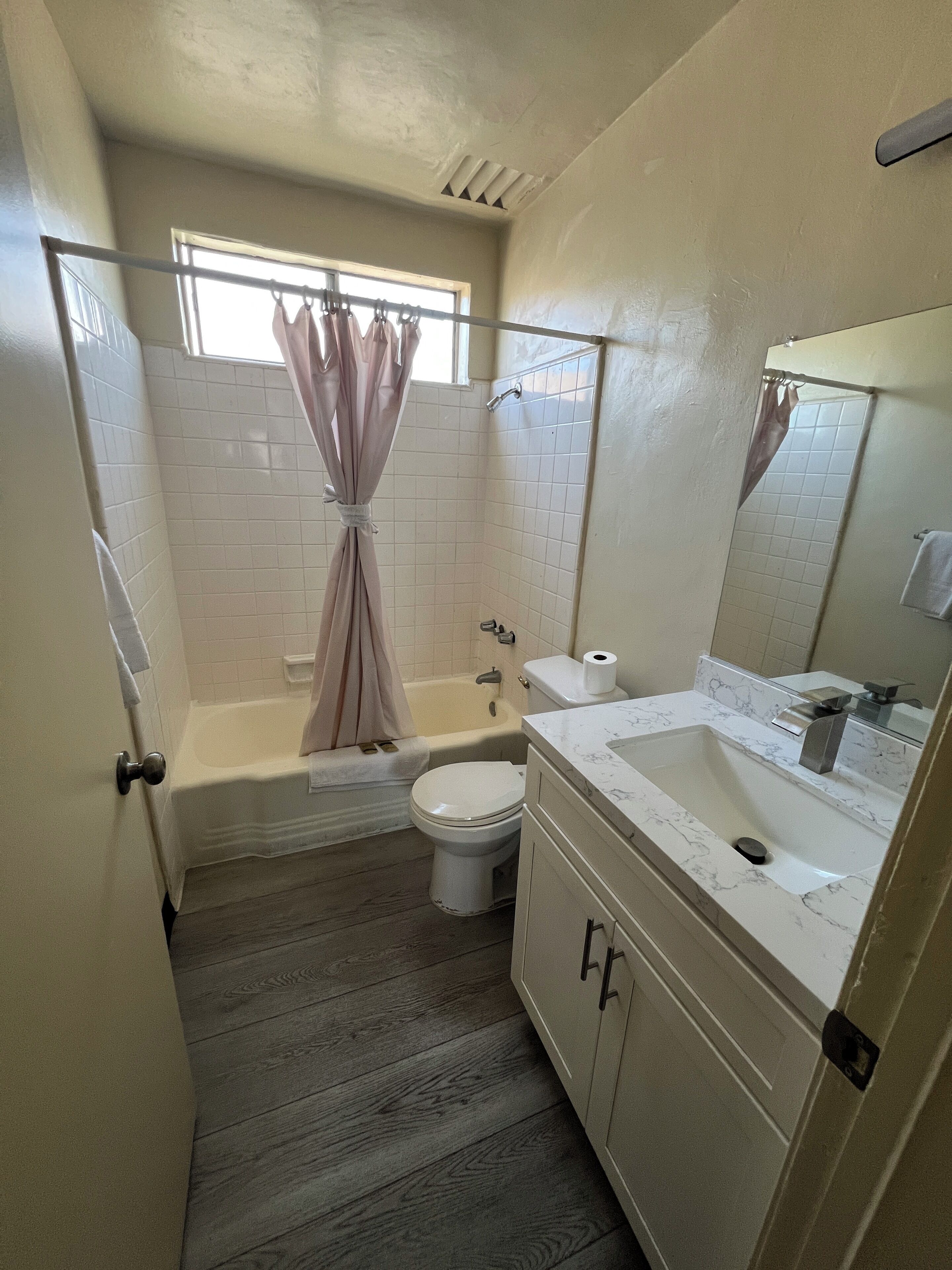 Un baño con bañera, inodoro y lavamanos.
