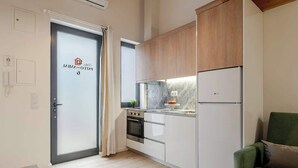 A modern kitchen with white cabinets, a built-in oven, and a refrigerator.