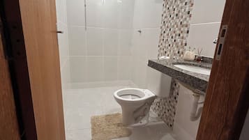 Een douche, handdoeken, zeep, toiletpapier
