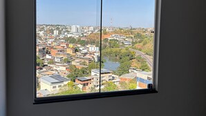 A room with a large window overlooking a cityscape. - Cozy apartment in Muriaé (Muriaé)