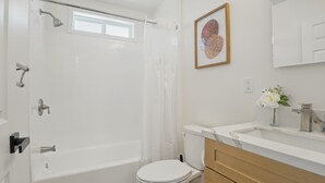 Een badkamer met een bad, toilet en wastafel.