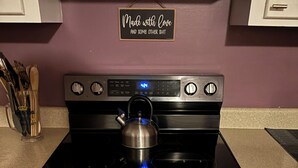 A kitchen with a stainless steel stove, a kettle, and a sign on the wall that reads "Made with Love and some other shit." - Quiet & Cozy 3bd2bth home (Columbia)