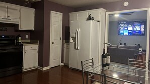 A kitchen with white cabinets, a refrigerator, a dining table with chairs, and a ceiling fan. - Quiet & Cozy 3bd2bth home (Columbia)