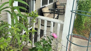 A porch with a white railing, a glass door, and a small table with chairs. - Quiet & Cozy 3bd2bth home (Columbia)