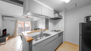 Una cucina moderna con isola centrale, elettrodomestici in acciaio inossidabile e un frigorifero nero.