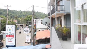 A building with a balcony, satellite dish, and a signboard advertising rooms for rent. - Unaway Holiday Home (Unawatuna)