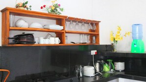 A kitchen with a stove, a sink, and a countertop with various kitchen items. - Unaway Holiday Home (Unawatuna)