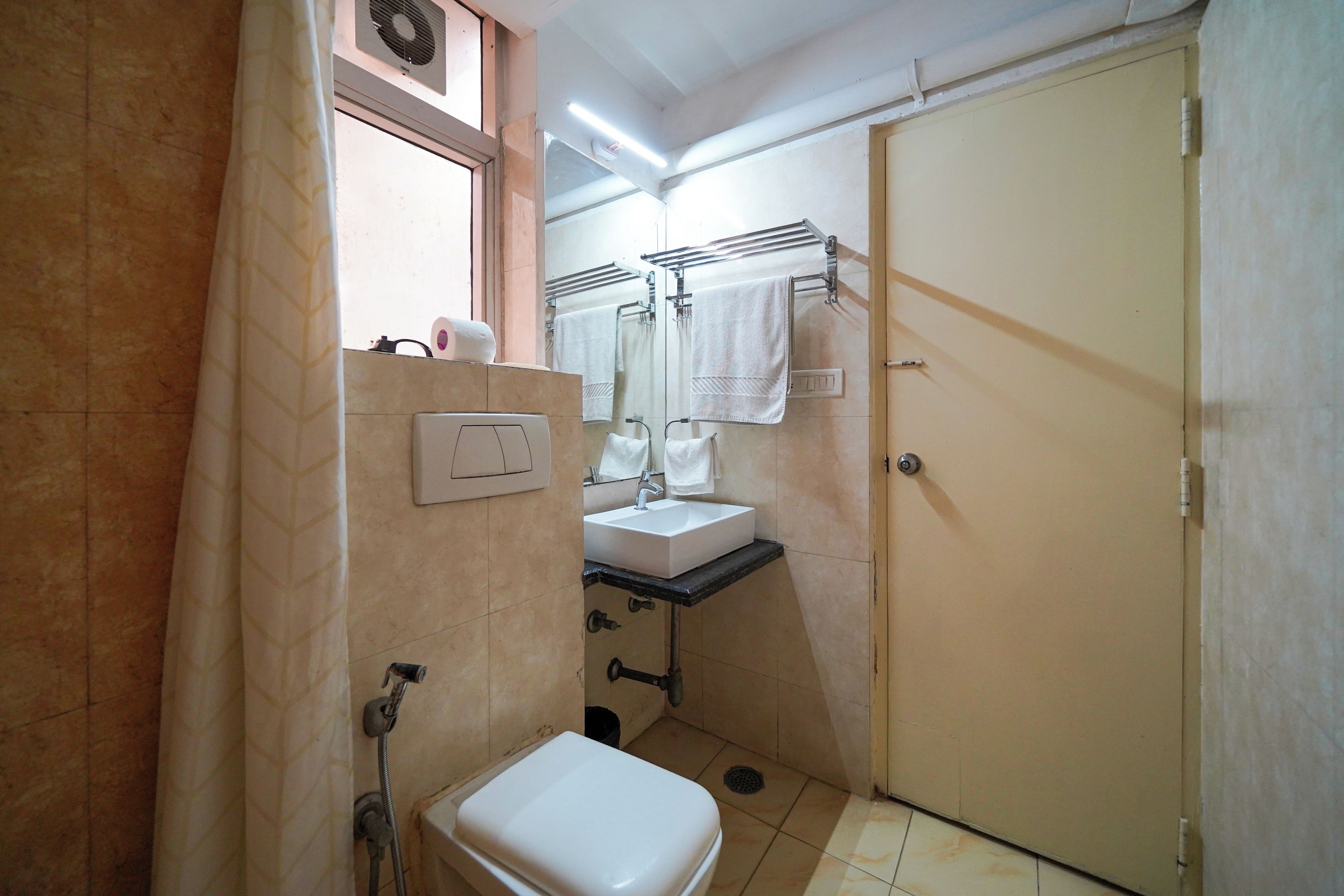 A small bathroom with a toilet, sink, and a towel rack.
