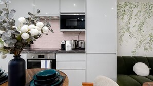 Een moderne keuken met een Bosch magnetron, een koffiezetapparaat en een broodrooster. Op het aanrecht staat een vaas met witte bloemen.