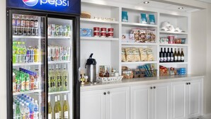 A kitchen area with a Pepsi refrigerator, shelves stocked with snacks, condiments, and bottled drinks. - Beautiful Marriott 2-bedroom villa with AC, fitness room on Hilton Head Island (Hilton Head Island)