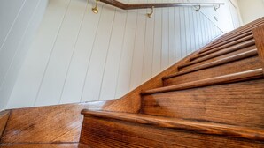 A wooden staircase with a metal handrail and brass handgrips. - Tranquil Cottage with Valley & Hills Views (Wonga Park)