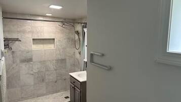 A modern bathroom with a shower, a sink, and a toilet.