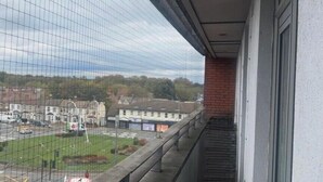 A balcony with a view of a parking lot and buildings in the background. - London 1 Bed Apartment close to Barking Station (Barking)