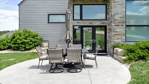 A patio with outdoor furniture and a stone wall.
