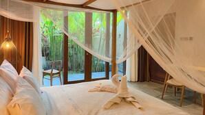 Un dormitorio con cama, una silla y vista a zonas verdes.