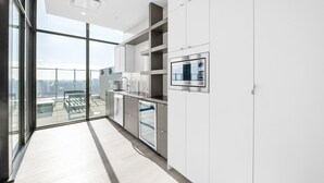 A modern kitchen with a large window, built-in appliances, and a view of the city.