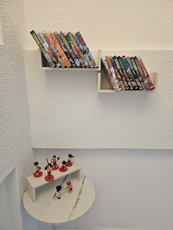 A shelf with books and a small figurine display. - Daldal Masil (Mokpo)