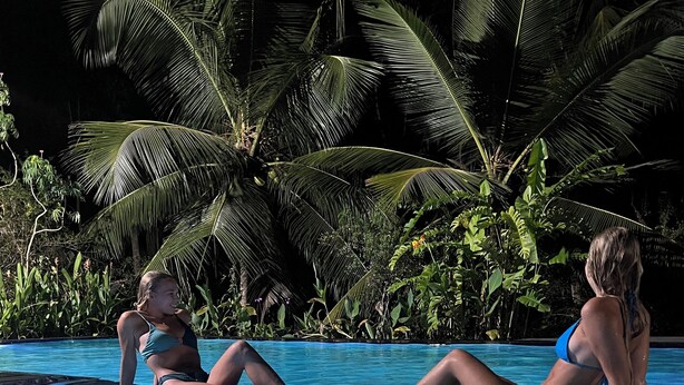 A clear pool with two people sitting on the edge. - Larala Villa With Private Pool (Hikkaduwa)