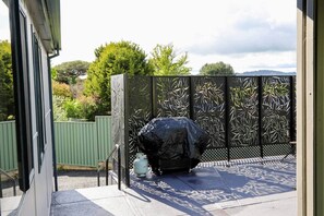 A patio with a decorative fence, a covered object, and a small table.