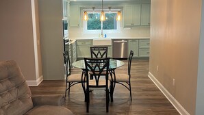 A modern kitchen with a dining area, wooden flooring, and a ceiling fan. - 4BR 3BA • 2 Master Suites • BBQ Patio • Near Ft Benning & CSU (Columbus)
