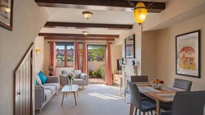 A spacious living room with a dining area, large windows, and a view of the outdoors.
