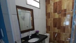 A bathroom with a sink, mirror, toilet, and a shower area. - Pousada Sítio Boas Novas  (Caucaia)