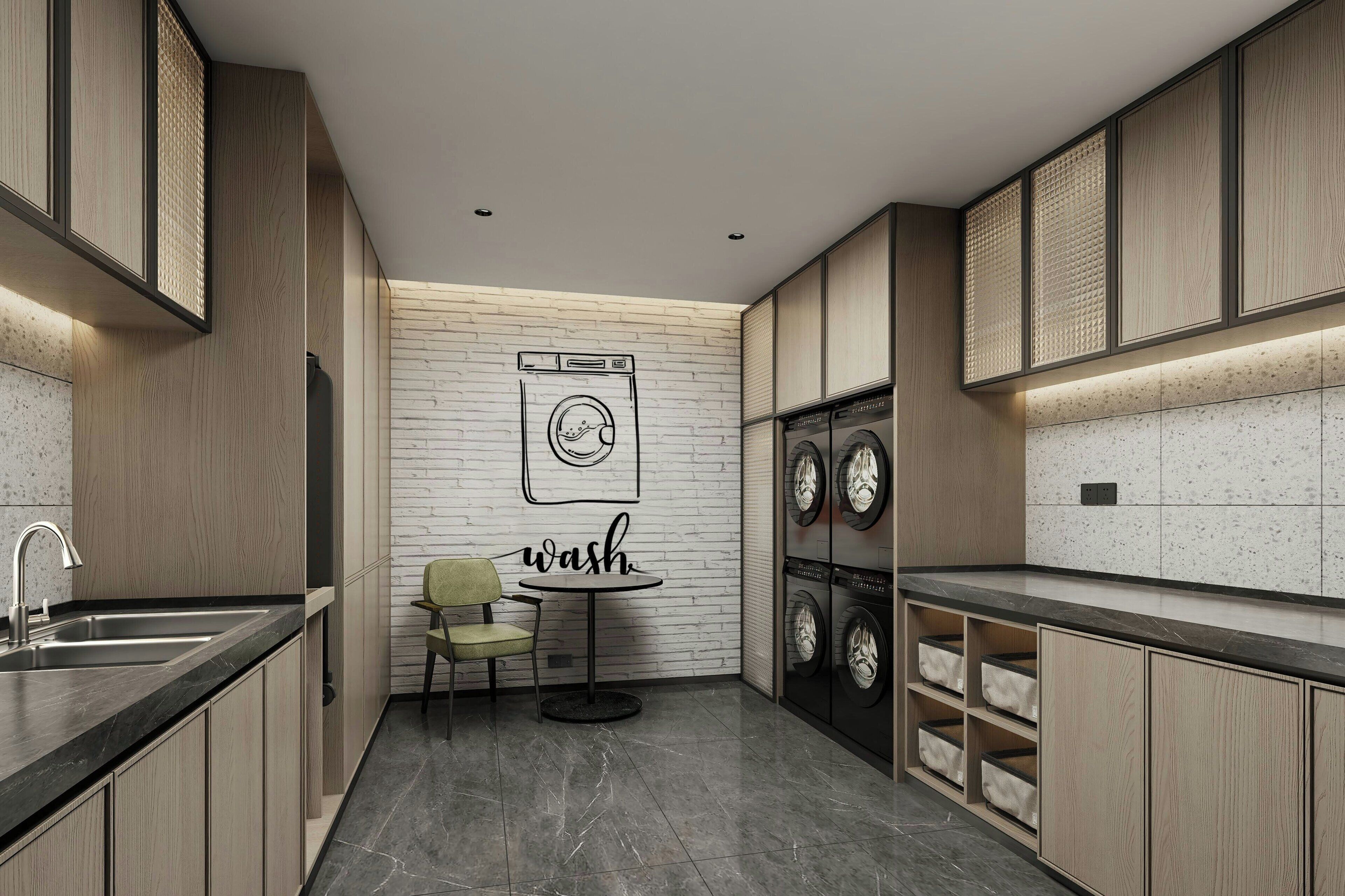 Een moderne keuken met een ingebouwde wasmachine, een spoelbak en een kleine tafel met een stoel.