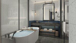Ein modernes Badezimmer mit freistehender Badewanne, einem Waschtisch mit Spiegel und einer Sitzbank mit Handtüchern.