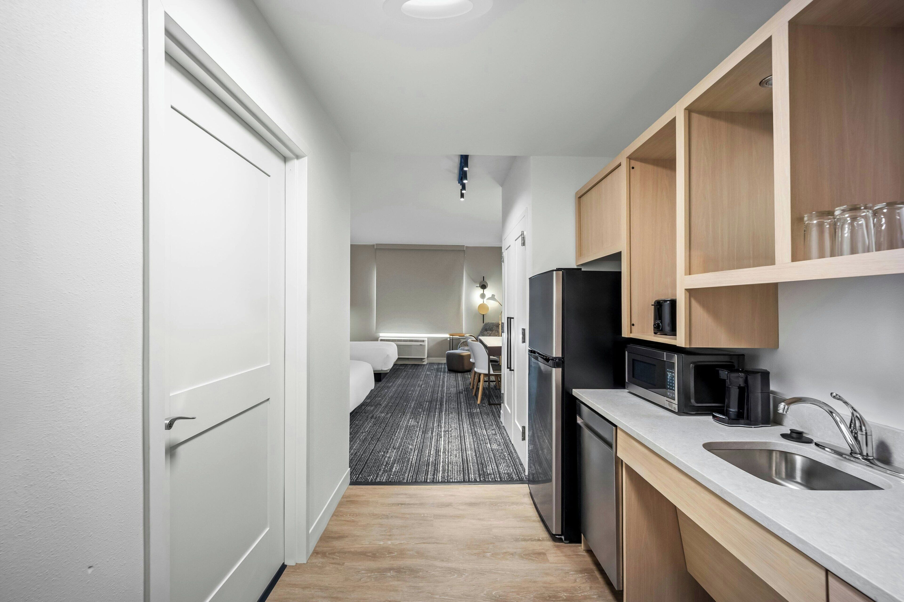 A modern kitchen with a refrigerator, microwave, and sink.