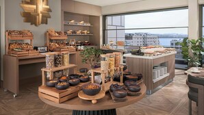 A modern breakfast buffet with various food items and a large window with a city view. - Delta Hotels by Marriott Istanbul Karakoy (Istanbul)