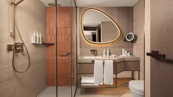 Ein modernes Badezimmer mit einer Duschkabine, einem Waschtisch mit Spiegel und einer Toilette.