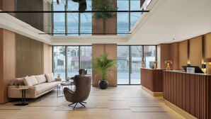 A modern lobby with a reception desk, seating area, and large windows. - Delta Hotels by Marriott Istanbul Karakoy (Istanbul)