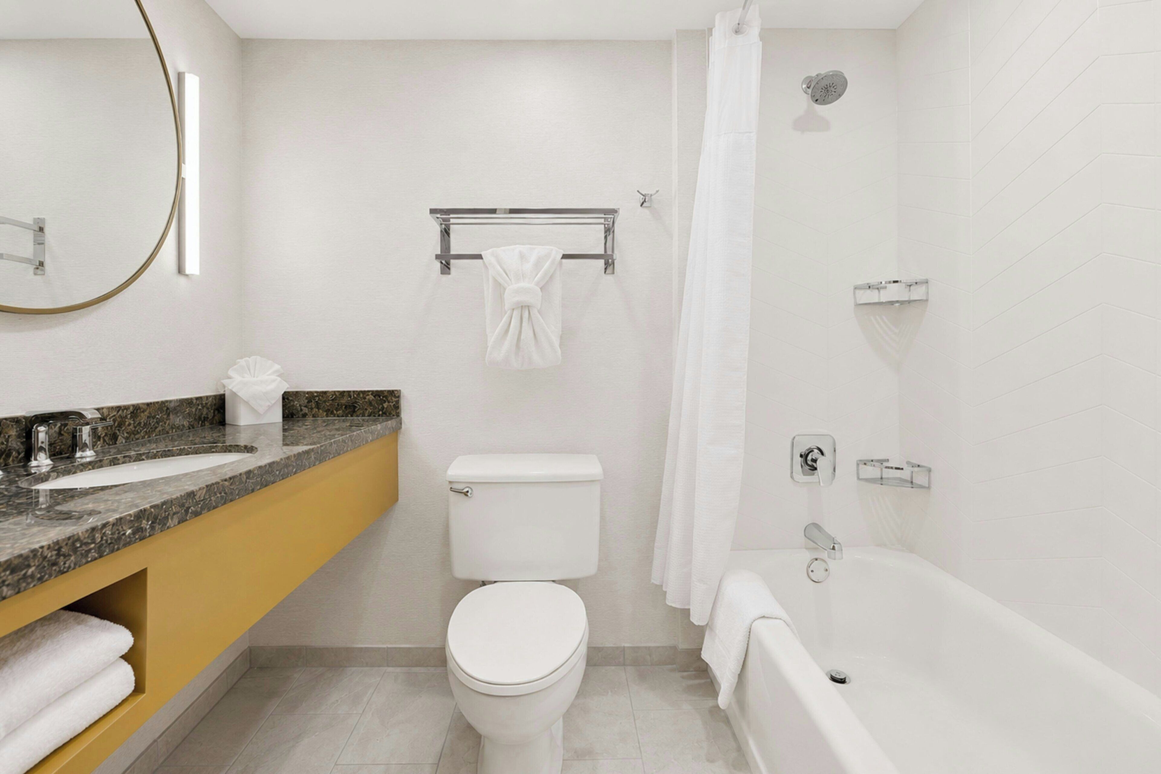 A modern bathroom with a toilet, sink, and bathtub.
