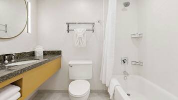 A modern bathroom with a toilet, sink, and bathtub.