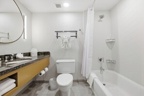 Un bagno moderno con toilette, lavabo, vasca e tenda da doccia.