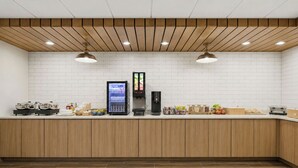 A clean, modern kitchen area with a built-in coffee machine, a refrigerator, and various food items on the counter. - Fairfield by Marriott Inn & Suites Mount Pleasant, WI (Mount Pleasant)