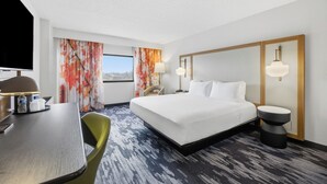 A hotel room with a bed, a desk, a chair, a TV, and a window with curtains. - Fairfield by Marriott Inn & Suites Mount Pleasant, WI (Mount Pleasant)