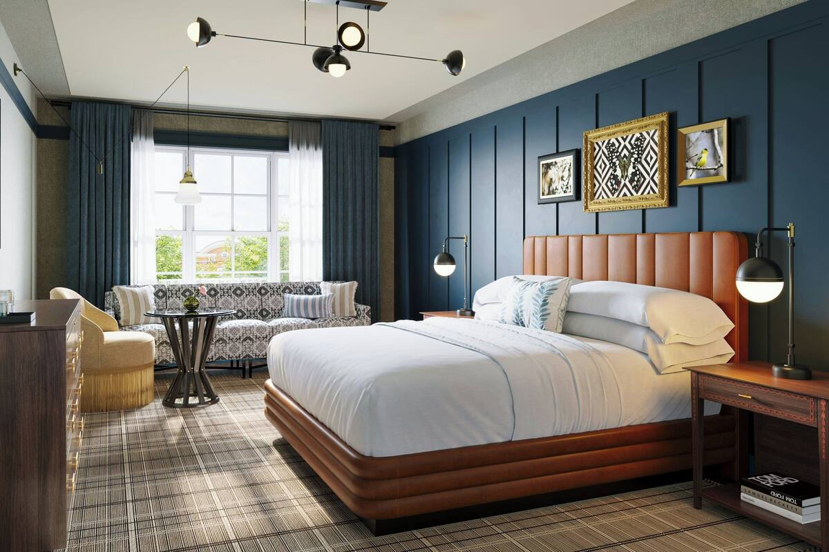 Een moderne slaapkamer met een groot bed, een bank, een klein tafeltje en een nachtkastje.