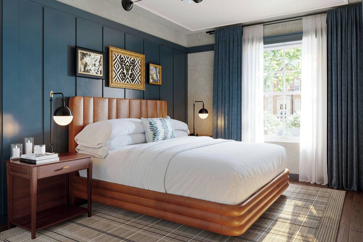 Een moderne hotelkamer met een groot bed, een nachtkastje, twee wandlampen en een raam met gordijnen.